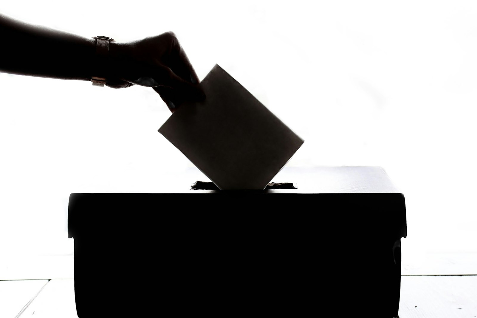 A voter casting a ballot into a ballot box