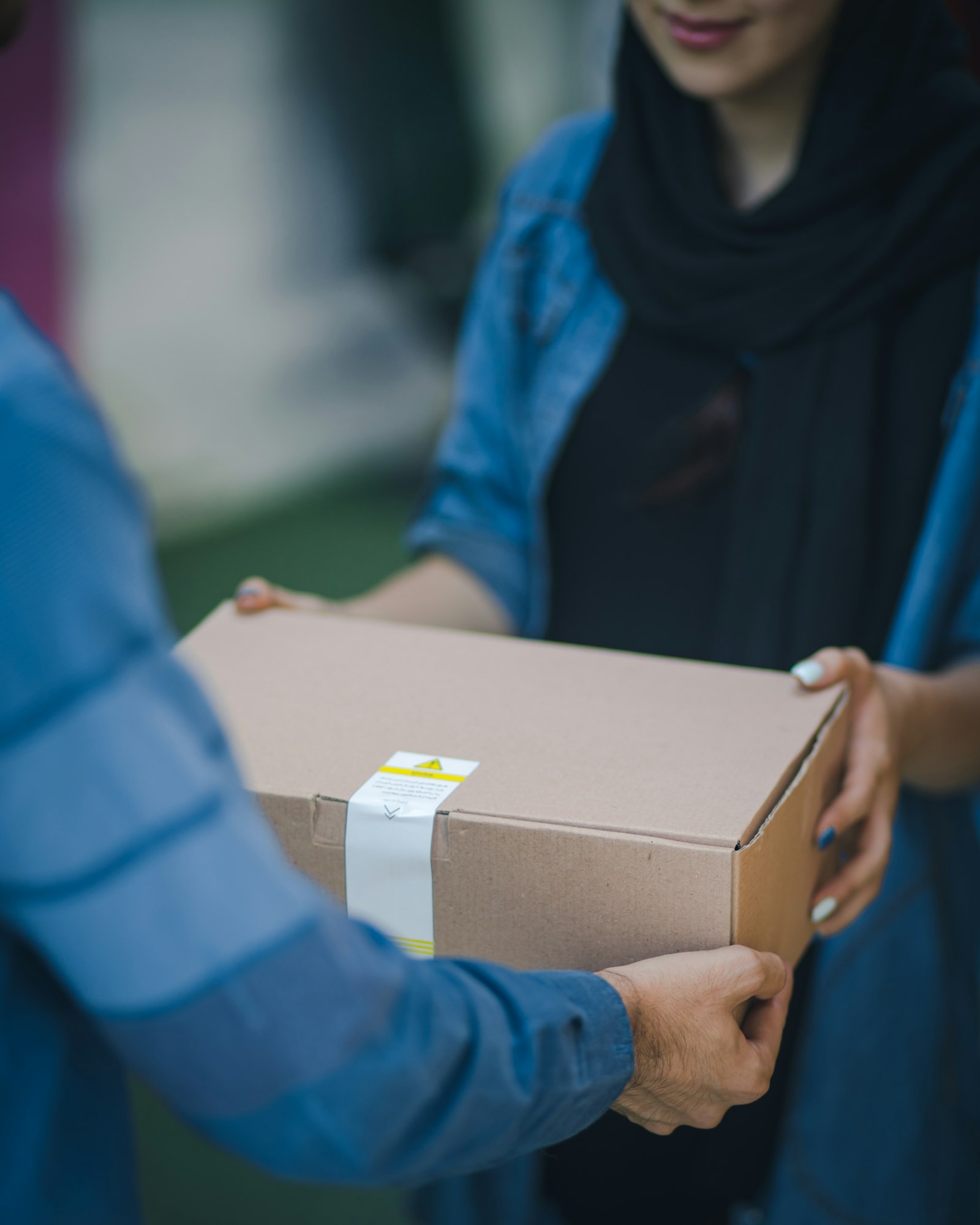 A delivery package handed over at a residential front door